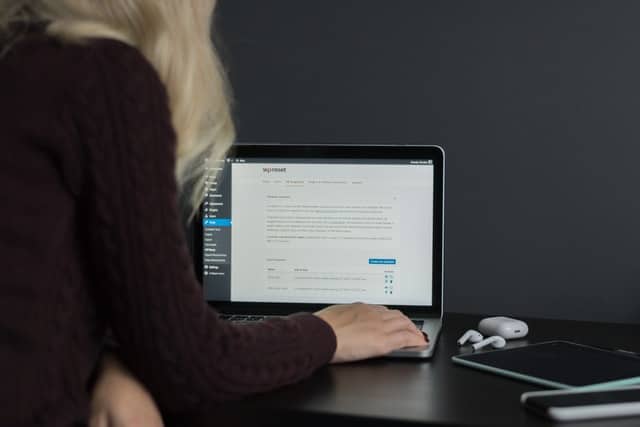 A woman edits in WordPress on a laptop computer.